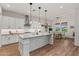 Bright kitchen boasts white cabinetry, center island, stainless hood, herringbone backsplash, & adjacent dining space at 11241 N Blakely St, Surprise, AZ 85388