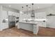 The bright kitchen features stainless appliances, a kitchen island, light countertops, and wood-look flooring at 11241 N Blakely St, Surprise, AZ 85388
