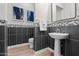 Elegant powder room with mosaic tile accents, pedestal sink, modern fixtures, and decorative artwork at 11241 N Blakely St, Surprise, AZ 85388