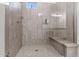 Contemporary shower with sleek tiled walls, a built-in bench, glass enclosure, and modern fixtures at 11241 N Blakely St, Surprise, AZ 85388