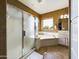 Bathroom features a glass-enclosed shower and separate tub under a bright window at 12403 W Monte Vista Rd Rd, Avondale, AZ 85392