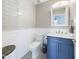 Cozy bathroom with blue vanity, decorative mirror, and stylish mosaic tile flooring for a modern touch at 12403 W Monte Vista Rd Rd, Avondale, AZ 85392