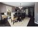 Open dining room with a rustic table, cushioned chairs, view of the kitchen, and stylish chandelier at 12403 W Monte Vista Rd Rd, Avondale, AZ 85392