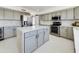 A spacious kitchen featuring gray cabinets, stainless steel appliances, and a large white countertop island at 12403 W Monte Vista Rd Rd, Avondale, AZ 85392