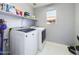 Bright laundry room featuring a washer, dryer, shelving, and natural light from the window at 12403 W Monte Vista Rd Rd, Avondale, AZ 85392