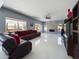 Comfortable living room with a stone fireplace, large windows, and a sectional leather sofa with red accents at 12403 W Monte Vista Rd Rd, Avondale, AZ 85392