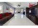 Open-concept living room featuring a stone fireplace, large windows, and a comfortable leather sofa with red pillows at 12403 W Monte Vista Rd Rd, Avondale, AZ 85392