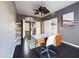 Home office with dark floors, a modern desk, chair, ceiling fan, and open doorway at 12403 W Monte Vista Rd Rd, Avondale, AZ 85392