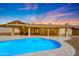 Inviting backyard pool and covered patio, perfect for entertaining under the bright dusk sky at 12448 N 76Th St, Scottsdale, AZ 85260