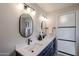 Well-lit bathroom featuring dual sinks, stylish black fixtures, and a modern design with a shower and separate toilet area at 12448 N 76Th St, Scottsdale, AZ 85260