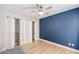 Bedroom with a ceiling fan, hardwood floors, and bi-fold closet doors at 12448 N 76Th St, Scottsdale, AZ 85260