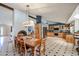 Expansive dining room open to the kitchen boasts a large wooden table, exposed beams, and black and white checkered floors at 12448 N 76Th St, Scottsdale, AZ 85260