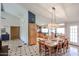 Open-concept living with dining table adjacent to kitchen with wood cabinets and black countertops, offering ample space at 12448 N 76Th St, Scottsdale, AZ 85260