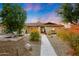 Beautiful single-story home featuring low maintenance desert landscaping and walkway leading to the front door at 12448 N 76Th St, Scottsdale, AZ 85260