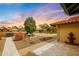 Home exterior showing a stone tile driveway, desert landscaping, and a mature shade tree at 12448 N 76Th St, Scottsdale, AZ 85260