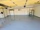 Clean, well-lit garage with epoxy flooring, storage cabinets, and utility sink at 12448 N 76Th St, Scottsdale, AZ 85260