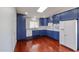 Modern kitchen with blue cabinets, stainless steel appliances, and wood flooring at 12448 N 76Th St, Scottsdale, AZ 85260