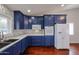 Modern kitchen with blue cabinets, stainless steel appliances, and wood flooring at 12448 N 76Th St, Scottsdale, AZ 85260
