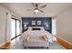 Spacious main bedroom with a stylish blue accent wall, seating area, and sliding glass doors to the patio at 12448 N 76Th St, Scottsdale, AZ 85260