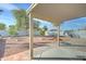 Relaxing backyard featuring a covered patio, low-maintenance landscaping, and a cozy fire pit area at 12621 W Aster Dr, El Mirage, AZ 85335