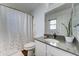 Well-lit bathroom with a shower with curtain, vanity sink, toilet, and contemporary fixtures and decor at 12621 W Aster Dr, El Mirage, AZ 85335