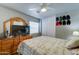 Bedroom with closet doors, ceiling fan, and TV on top of a wooden dresser at 12621 W Aster Dr, El Mirage, AZ 85335