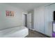 Simple bedroom with a twin bed, wooden floors, closet doors, and a TV set on a dresser at 12621 W Aster Dr, El Mirage, AZ 85335