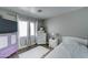 Comfortable bedroom with a twin bed, wooden floors, a teddy bear, and a window with curtains at 12621 W Aster Dr, El Mirage, AZ 85335