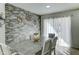 Elegant dining area featuring a modern stone accent wall, a contemporary table, and lots of natural light at 12621 W Aster Dr, El Mirage, AZ 85335