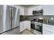 Contemporary kitchen with stainless steel appliances, sleek white cabinetry, and efficient layout at 12621 W Aster Dr, El Mirage, AZ 85335