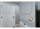 Laundry room featuring a stacked washer and dryer set, next to a door at 12621 W Aster Dr, El Mirage, AZ 85335