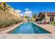 Relaxing backyard with a long, narrow pool, sun loungers, and privacy landscaping for a serene outdoor experience at 130 W Palm Ln, Phoenix, AZ 85003