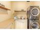 Functional laundry room with stacked washer and dryer, ample counter space, and built-in shelving at 130 W Palm Ln, Phoenix, AZ 85003