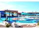 Resort-style pool with multiple swimming areas, sun shades, lounge chairs, and a well-appointed recreation building at 13029 N 111Th Ave, Sun City, AZ 85351