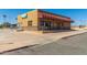 Corner view of the Lawn Bowls building, featuring awning, stone accents, and well-kept parking area at 13029 N 111Th Ave, Sun City, AZ 85351