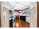 Galley kitchen featuring light countertops, dark cabinets, and wood floor at 13029 N 111Th Ave, Sun City, AZ 85351