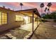 Twilight view of backyard featuring covered patio, decorative rock landscaping, and lush palm trees at 14013 N 57Th Pl, Scottsdale, AZ 85254
