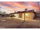An exterior view of the backyard showcasing a covered patio, rock landscaping, and mature palm trees at 14013 N 57Th Pl, Scottsdale, AZ 85254