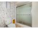 Bathroom featuring a toilet, frosted glass enclosed shower, and wallpapered accent wall at 14013 N 57Th Pl, Scottsdale, AZ 85254