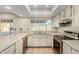 Bright kitchen with white cabinetry, modern appliances, and a window above the sink overlooking the backyard at 14013 N 57Th Pl, Scottsdale, AZ 85254