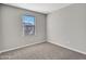 Neutral bedroom with plush carpeting, a window for natural light, and ample space at 14247 W Bronco Trl, Surprise, AZ 85387
