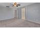 Bedroom with neutral walls, carpet flooring, ceiling fan, and ensuite bathroom at 14247 W Bronco Trl, Surprise, AZ 85387