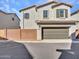 Two-story home with two car garage, block wall, and desert landscaping at 14247 W Bronco Trl, Surprise, AZ 85387