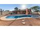 Backyard pool with a pool with diving board, concrete patio, and lush landscaping at 14251 N 182Nd Ave, Surprise, AZ 85388
