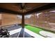 Covered back porch includes a ceiling fan, artificial turf, and roll down sun shades at 17641 W Corrine Dr, Surprise, AZ 85388