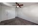 A bedroom featuring a ceiling fan, two doors, and carpeted floor at 17641 W Corrine Dr, Surprise, AZ 85388