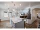 Open concept kitchen featuring a large island with seating, modern pendant lighting, and seamless flow to living spaces at 17641 W Corrine Dr, Surprise, AZ 85388