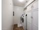 Functional laundry room with washer, dryer, and ample storage space provided by the built-in cabinets and shelving at 17641 W Corrine Dr, Surprise, AZ 85388