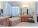 Well-lit bathroom featuring dual sinks, soaking tub, and vanity area at 19973 N Monte Ln, Maricopa, AZ 85138
