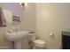 Half bathroom with a pedestal sink, toilet, and framed mirror at 19973 N Monte Ln, Maricopa, AZ 85138